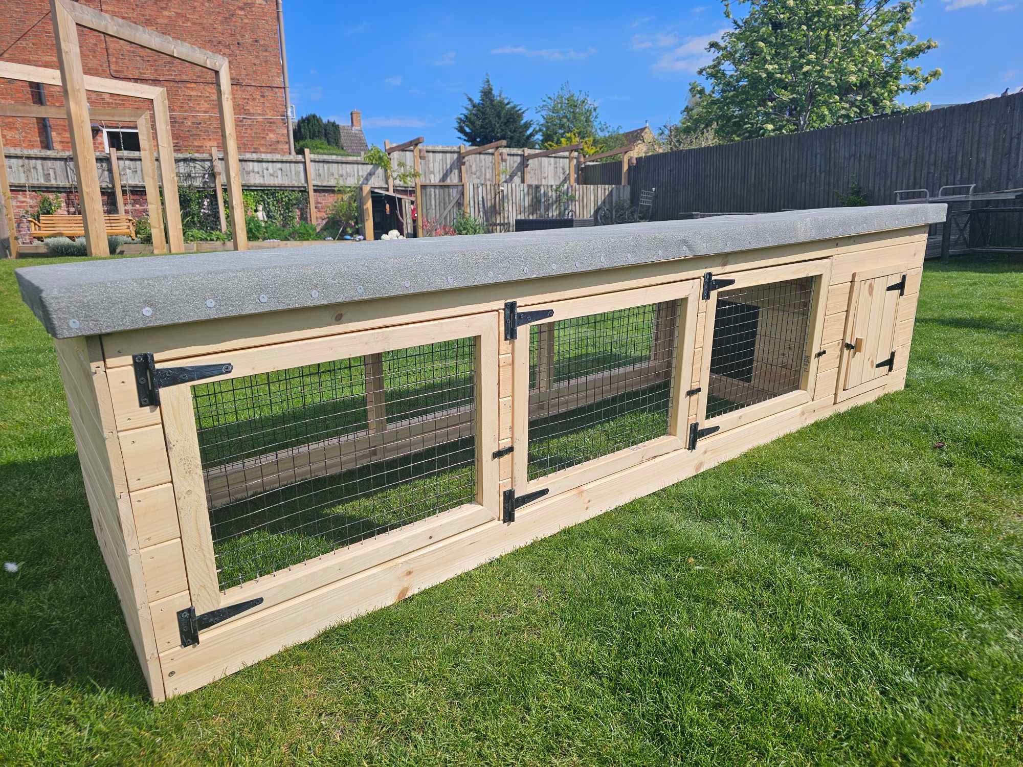 Handcrafted timber dog kennel and run in a sunny garden
